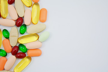 Many colorful pills on white background