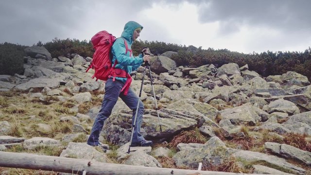Hiking - hiker woman on trek with backpack, living healthy active lifestyle. Stabilized Slow Motion 120 fps. Epic Steadicam shot. Strong woman walking on the mountain trail. Misty Mountains Series.   