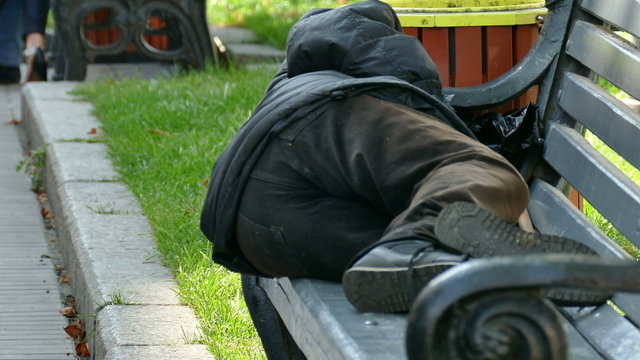 Homeless tramp beggar man sleeps on  city bench .4K 3840x2160 