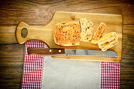 Sliced Bread with Sesame Seeds on a Wooden Board
