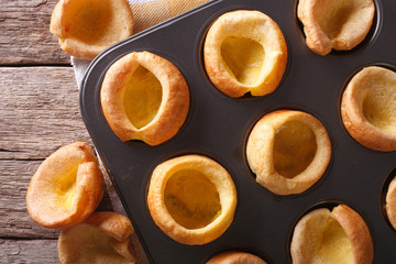 Fresh Yorkshire puddings in baking dish macro. horizontal top view
