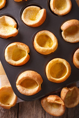 Fresh Yorkshire puddings in baking dish macro. vertical top view
