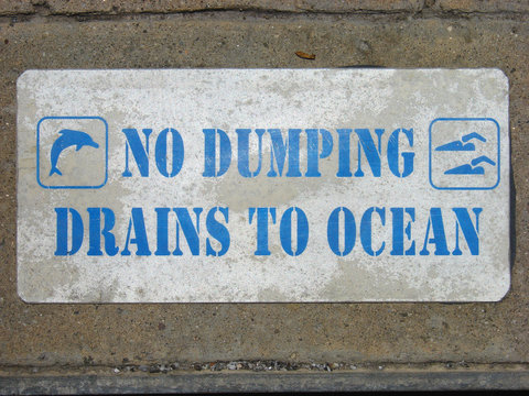 no dumping drains to ocean sign on concrete