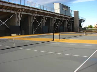 Foto op Canvas tennis courts with stadium in background © jdoms