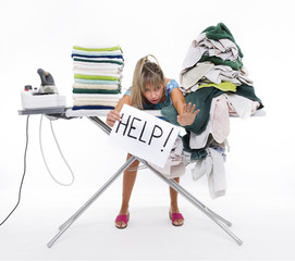 Woman behind a table covered with clothes to be ironed, displays a sign with help
