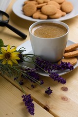 Obraz na płótnie Canvas Lavender next to cup of creamy coffee