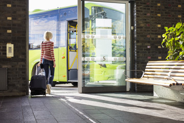 Female traveler going on the bus at terminal