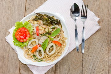 stir fried spaghetti with squid on wood background