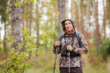 Man with hiking equipment walking in forest