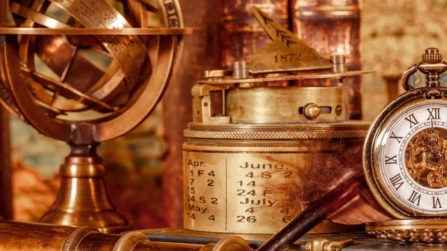 Vintage still life. Vintage magnifying glass lies, pocket watch, old book and astrolabe on an ancient world map in 1565.