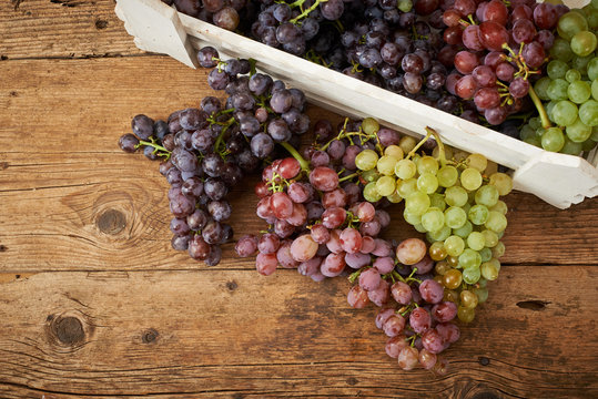 bunch of fresh grapes on wooden kitchen bench