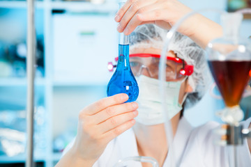 Scientific researcher holding at a liquid solution in a lab