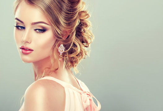 Beautiful model with  elegant hairstyle . Beautiful woman with fashion wedding hairstyle and colourful makeup