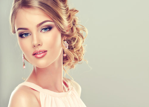Beautiful model with  elegant hairstyle . Beautiful woman with fashion wedding hairstyle and colourful makeup
