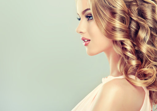 Smiling Beautiful girl light brown hair with an elegant hairstyle , hair wave ,curly hairstyle

