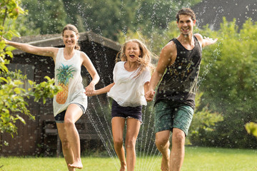 Familie läuft über einen Wassersprenger