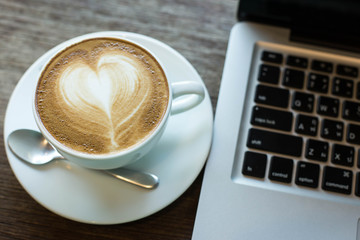 Hot art Latte Coffee in a cup on wooden table and Coffee shop bl