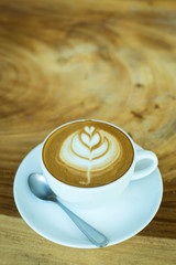 Hot art Latte Coffee in a cup on wooden table and Coffee shop bl