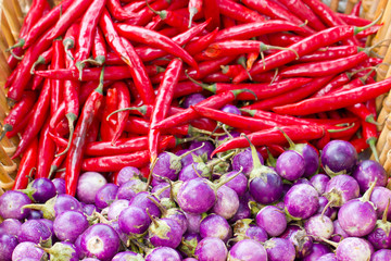 Heap of purple eggplant and red chili.