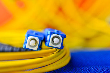 Fiber optic connectors close up on a colourful background.