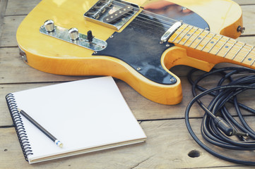 Telecaster with notepad on wood table