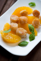 Closeup of fried sea scallops with orange fillet, studio shot