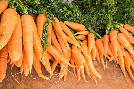 few bunches of carrots at a market for sale
