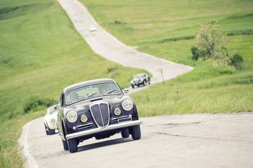 Fototapeta premium Auto classica che percorre una strada piena di curve