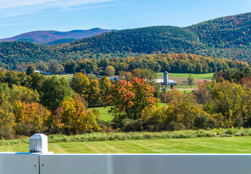 rural farm scene with barn and silo seen in fall foliage season in Vermont
