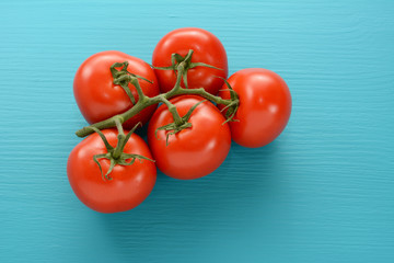 Fresh tomatoes on the vine on a blue wooden surface