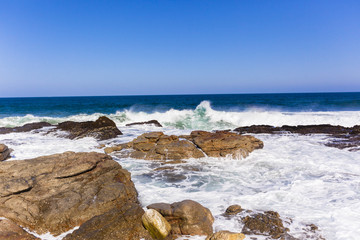 Fototapeta na wymiar Rocky Coastline Waves ocean blue landscape