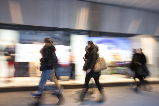 Shopping crowd walking on sidewalk, motion blur