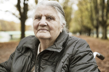 Seniorin im Herbst im Rollstuhl im Park