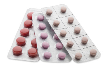 Set of colorful pills in a blister pack on white background