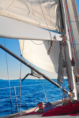 Sailing, with closeup of sail, rigging and ropes. Afternoon warm light.