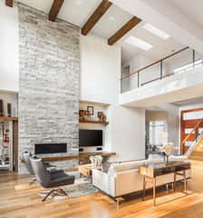 Beautiful living room interior with hardwood floors, vaulted ceiling, and fireplace in new luxury home