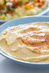 Tasty arabic hummus food served on a blue bowl with rice and spices