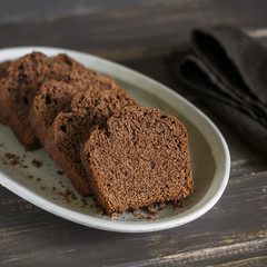 pieces of chocolate cake on the oval dish on dark wooden background