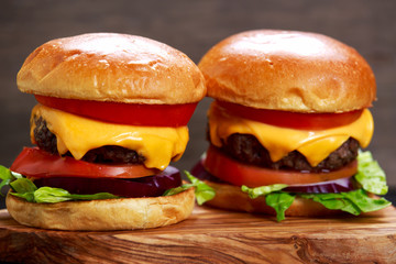 Homemade Cheeseburgers top with onion, tomato, lettuce and cheese.