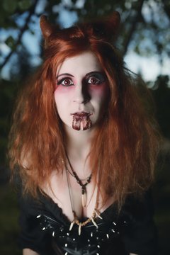 Portrait girl with red hair and bloody face vampire, murderer, psycho, halloween theme, bloody woman