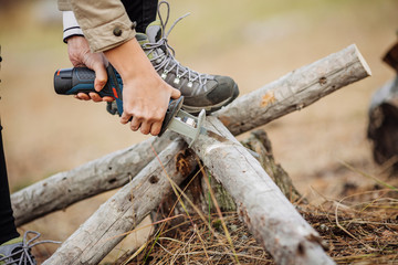 woman cutting a wood with a hand electric saw