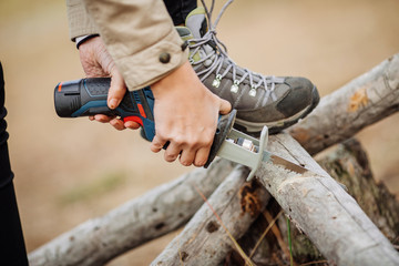 woman cutting a wood with a hand electric saw