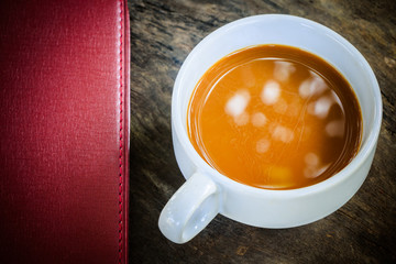 cop of coffee with notebook on old desk