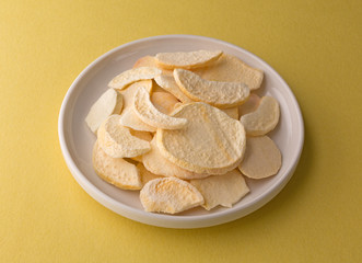 Plate of dried peach slices on a yellow table