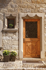 Vintage wood medieval door in rural stone wall house,Switzerland