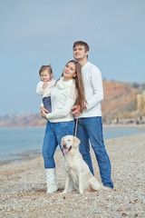 happy family on the beach with labradors