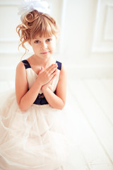 Fototapeta premium Cute baby girl 4-5 year old posing in room. Sitting on floor. Birthday celebration. Looking at camera. Childhood. 