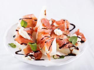 Salad melon with Serrano ham on a white background.selective focus