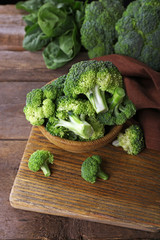 Fresh broccoli with spinach in bowl on wooden table close up © Africa Studio