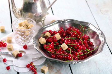 Fresh red currants with sugar on table close up